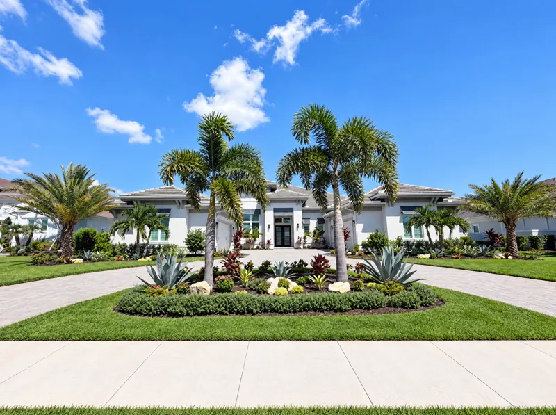 Driveway island planting: palms, agave, and a hedge border